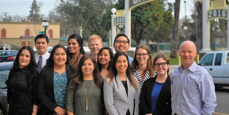 McGeorge Immigration Law Clinic students and staff attorney Blake Nordahl across the street from a park in Sacramento's Oak Park neighborhood