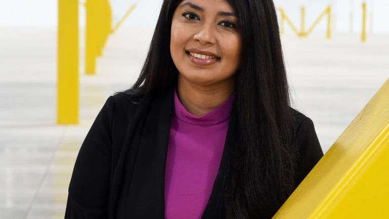 A portrait of Mariana Corona Sabeniano in front of a yellow and white backdrop