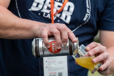 Hand pours beer into glass
