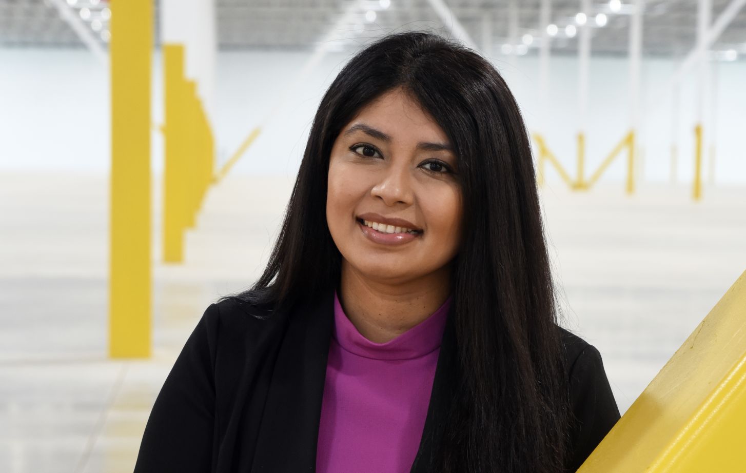 A portrait of Mariana Corona Sabeniano in front of a yellow and white backdrop