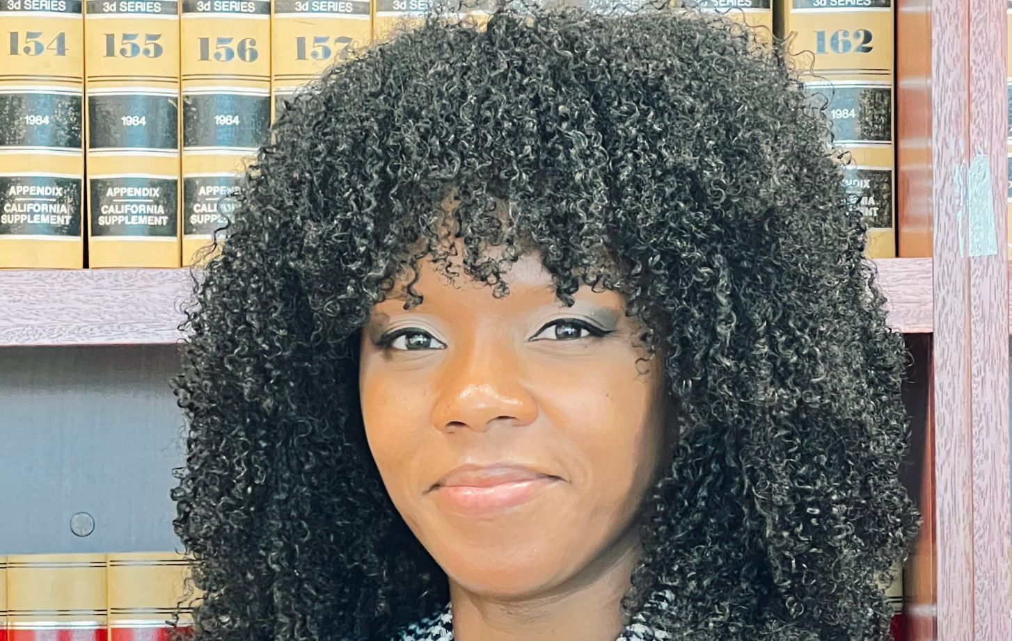 A woman standing in front of law books