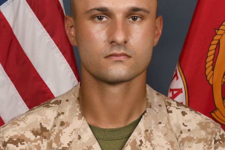 A portrait of Ian Worrell, wearing a military uniform. The background of the image is an American flag and another red flag.