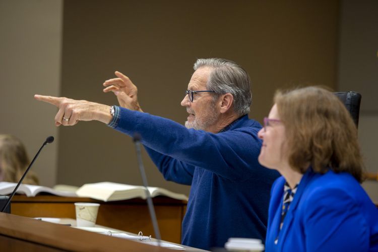 A man points in a courtroom