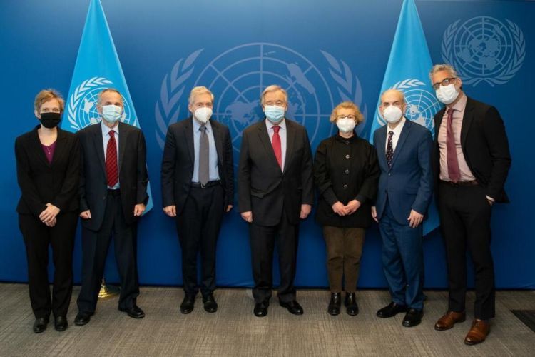 Seven people pose for a photo at the United Nations headquarters in New York 