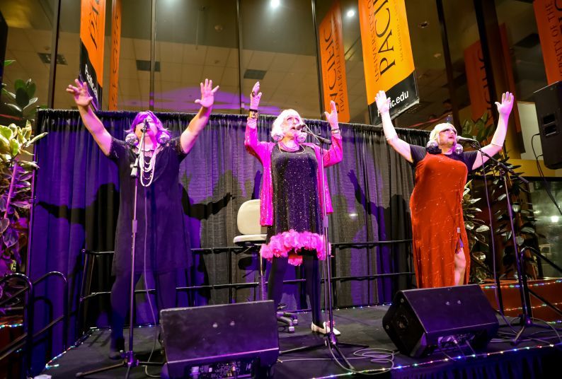 Three men sing and perform in drag