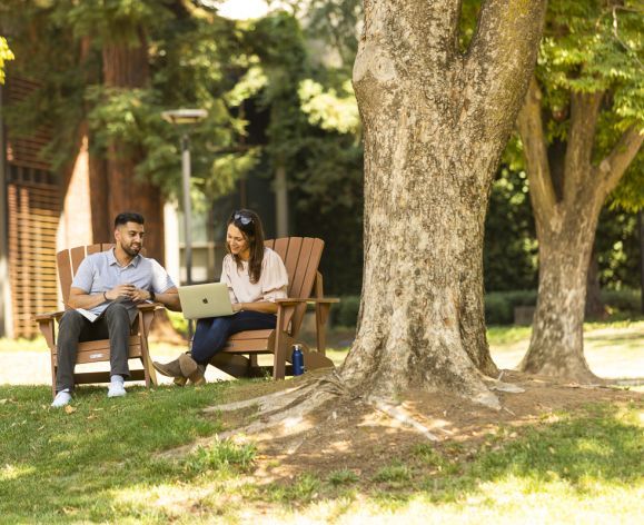 Two people sitting under a tree