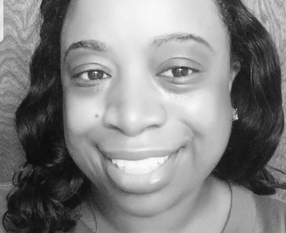 A black and white photo of a woman smiling
