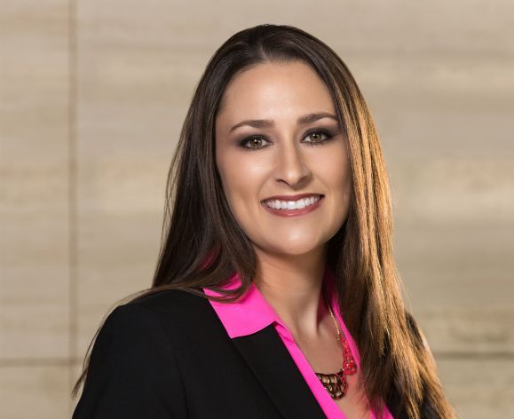 A woman in a suit poses for a photo